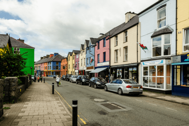 Cars parked outside the colourful buildings of Llanberis High Street in Llanberis, Wales