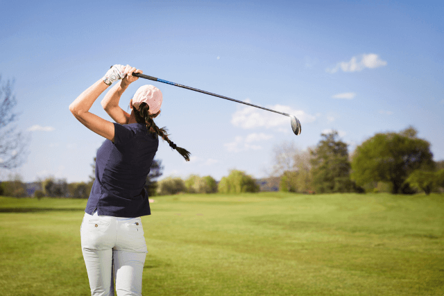 Woman playing golf in North Wales with blue skies
