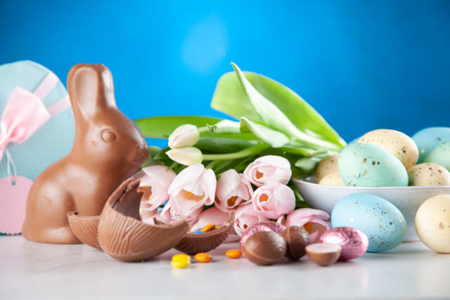 Chocolate rabbit, bunch of roses, and chocolate eggs.