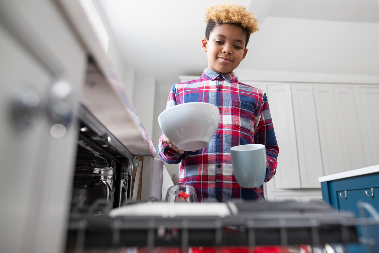 Kid putting bowls into dishwasher