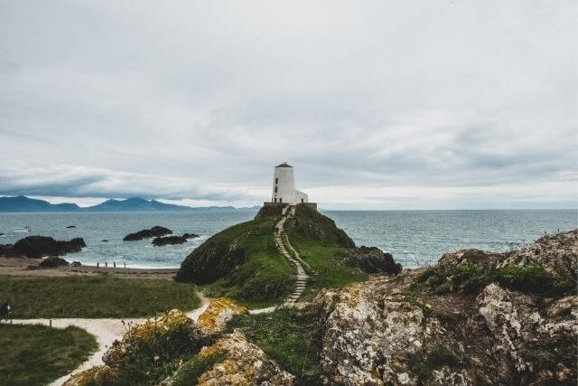 llanddwyn island and Lighthouse, with views of Snowdonia in background