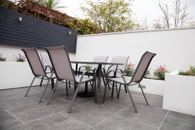 Grey garden furniture on a grey tiled floor.