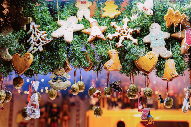 Selection of gingerbread men, stars, hearts, and stockings hanging at a christmas market. 